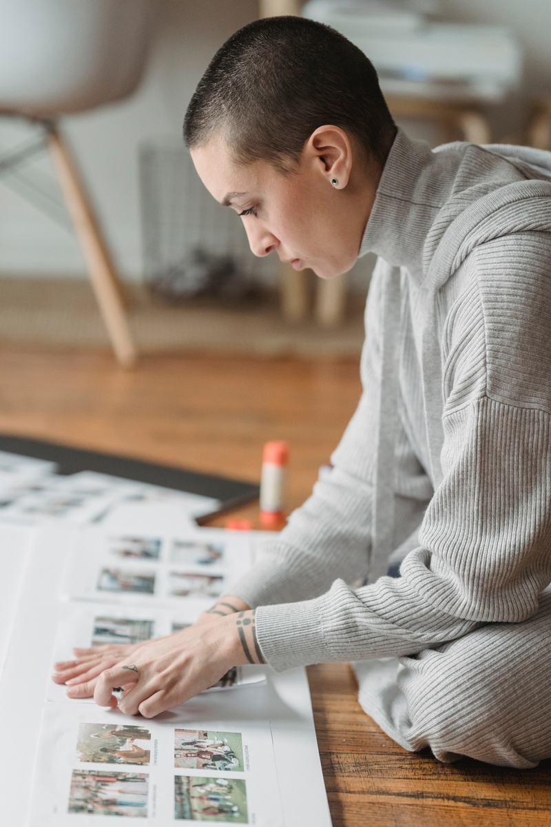 Woman creating photo collage on paper at home