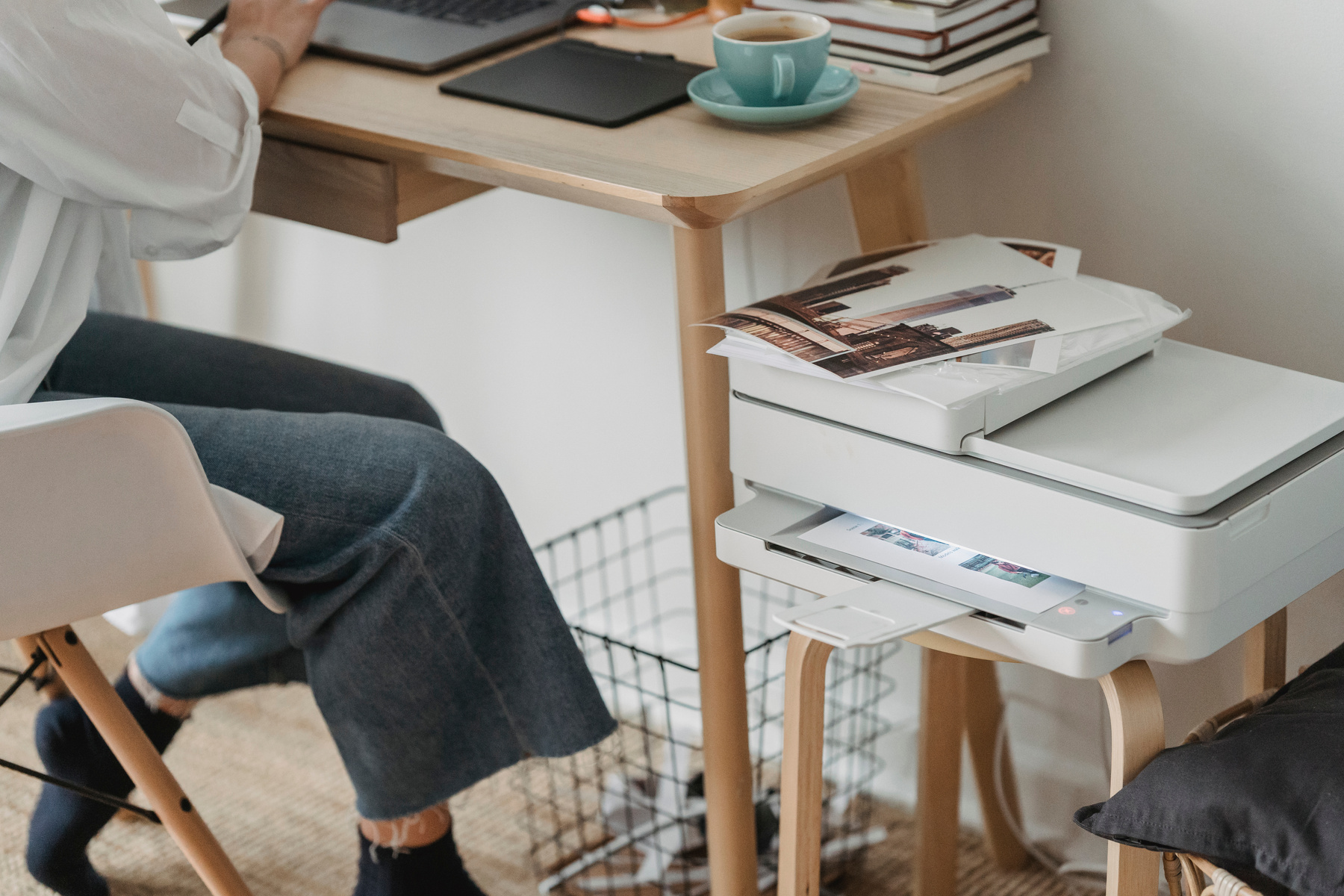 Woman working on laptop and printing pictures